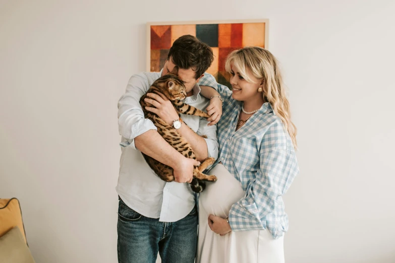 a couple holding their cat in the living room