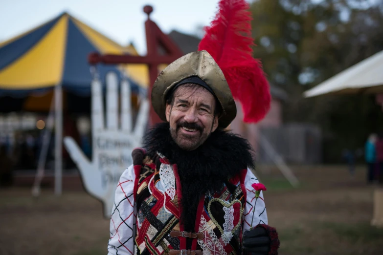 a man with a beard in costume is smiling at the camera