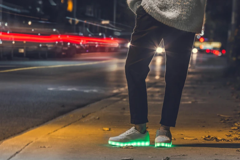 someone wearing sneakers standing on their shoes near the street