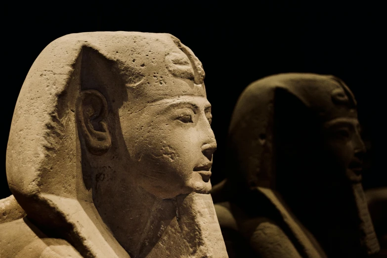 two statues of ancient egypt standing next to each other