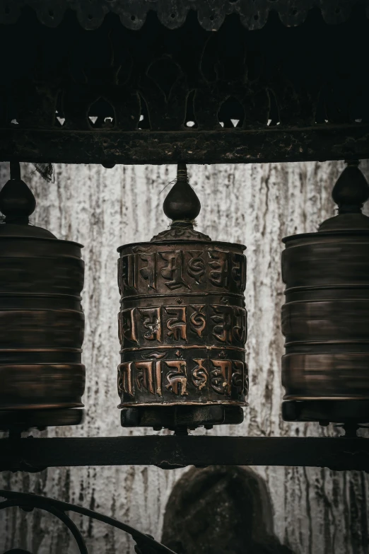 four bells hanging next to each other in a room