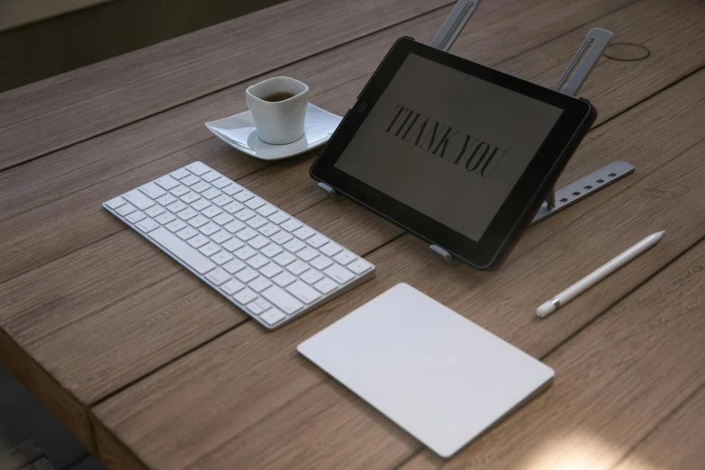 table that has a tablet and keyboard on it