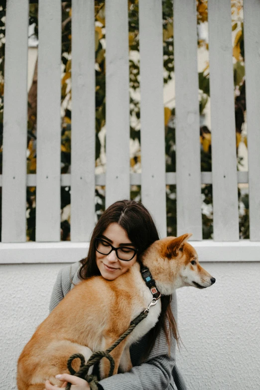 a person holding two dogs and wearing glasses