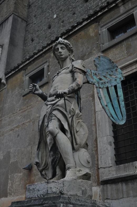 the statue is next to the building with large windows