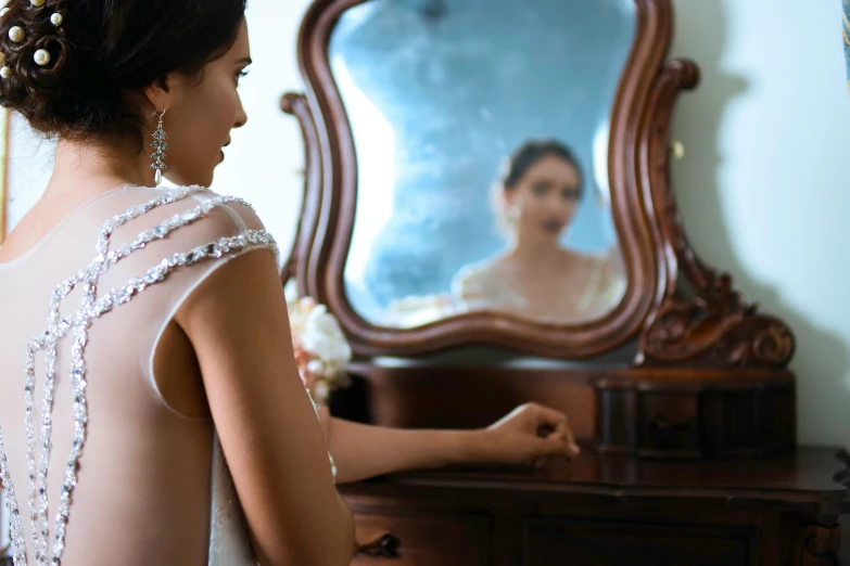 an up close picture of a bride looking in the mirror