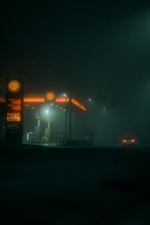 a gas station in the dark with two people standing next to it