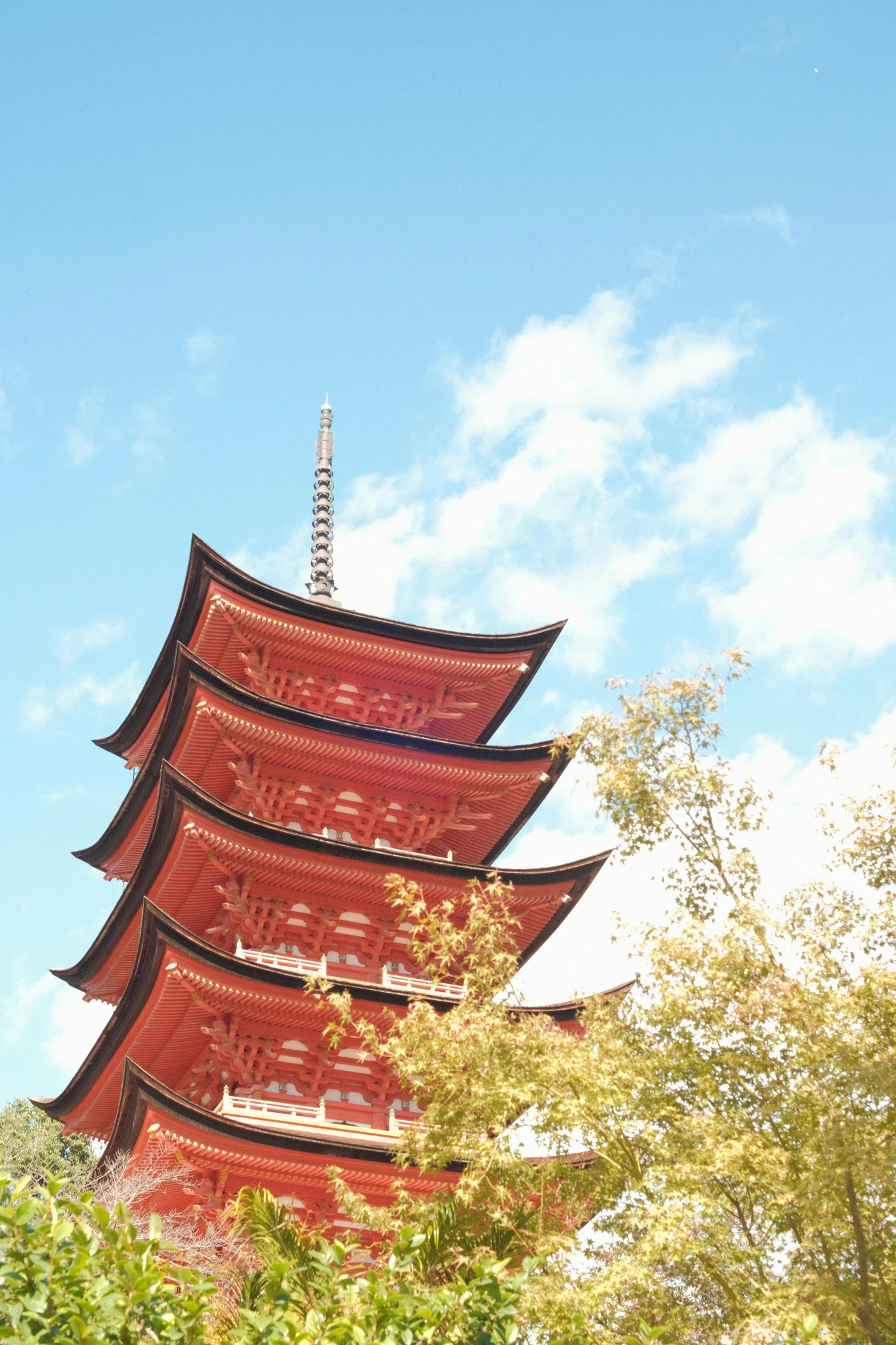 a tall pagoda sitting in front of a tree covered forest