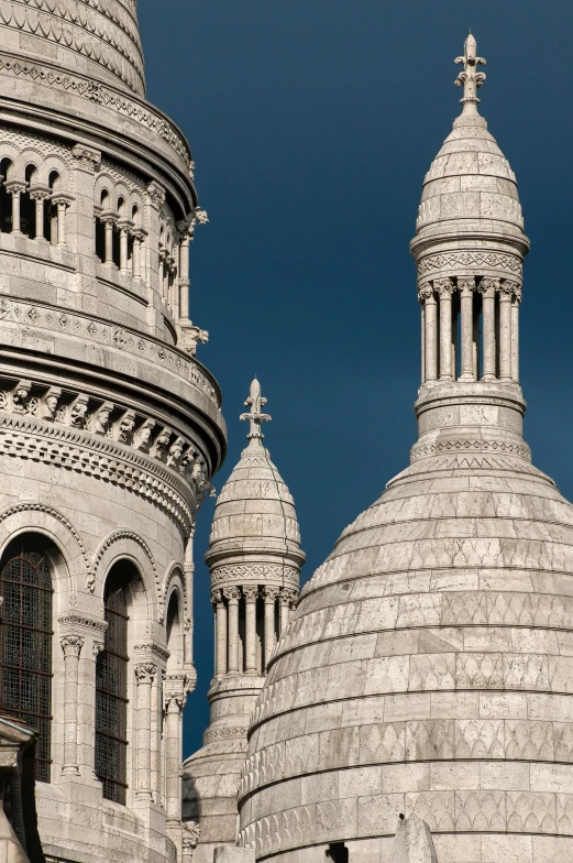 a large white building with three pointed towers and a cross on the top