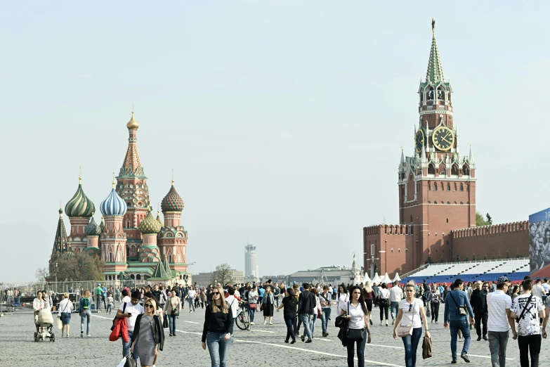 people walking in the middle of a public square in front of a large building