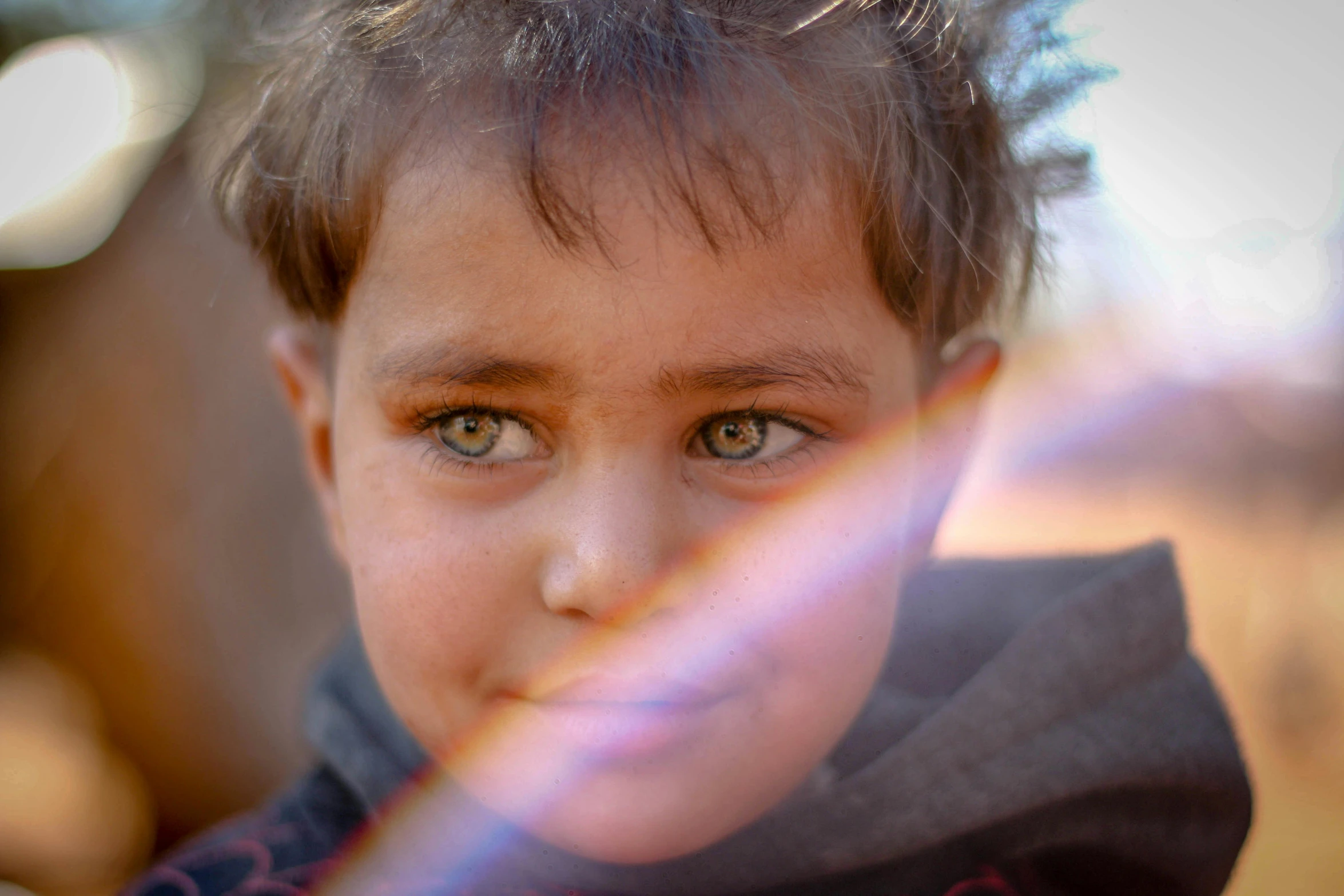 the child is looking at soing outside with bright sunlight