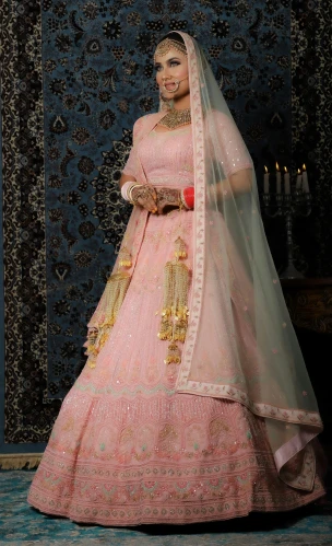 a woman in a pink bridal gown is holding her hands together