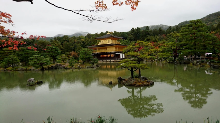 a building with trees in front of it sitting next to water