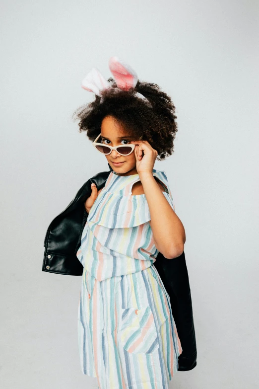 a little girl wearing a bunny ears wig talking on the phone