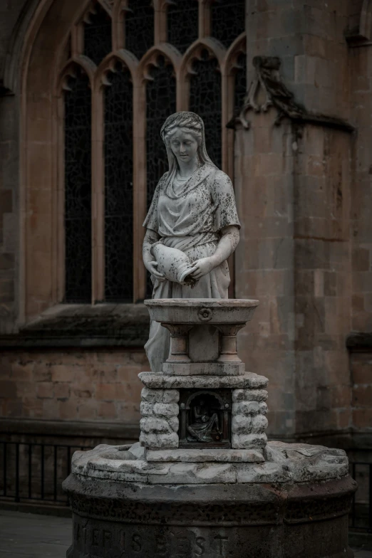 an outdoor statue on top of a brick bench