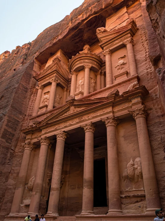 people stand on the steps of the ancient ruins