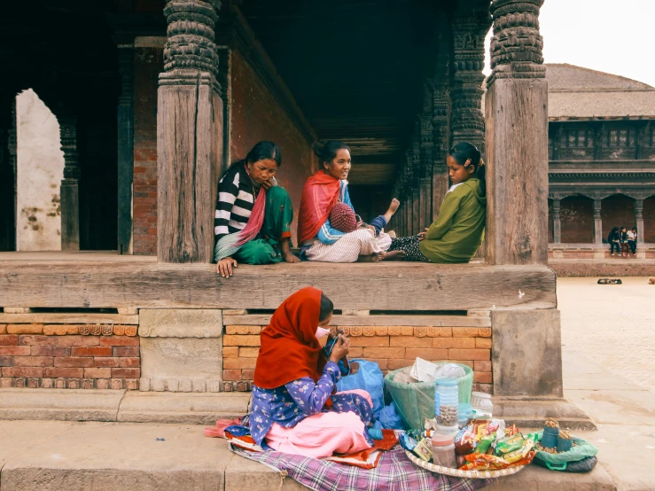 three women on a ledge in an indian temple