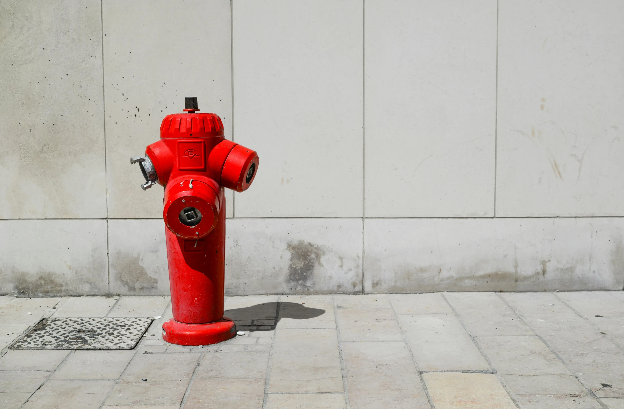 a red fire hydrant on the corner of a city street
