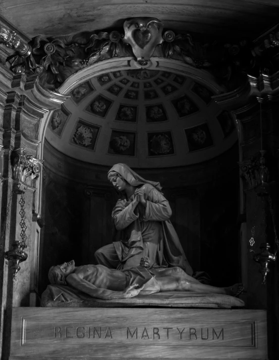 a statue of mary on top of a marble platform