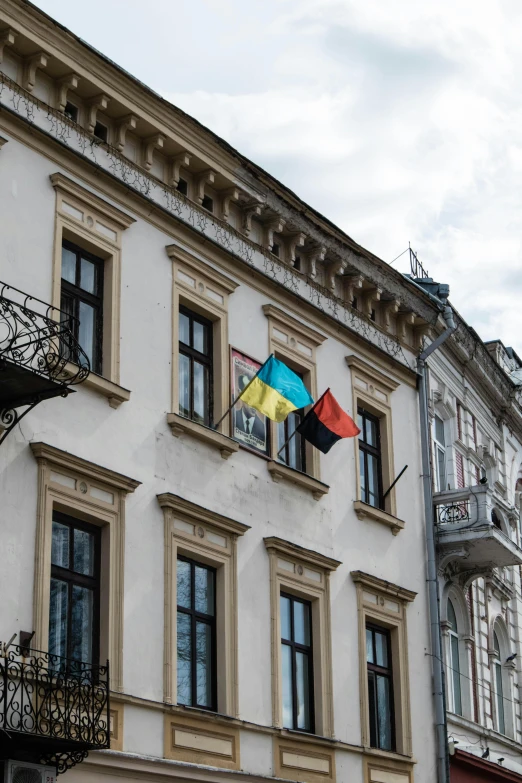 an image of the building with windows and a colorful kite flying out of the window