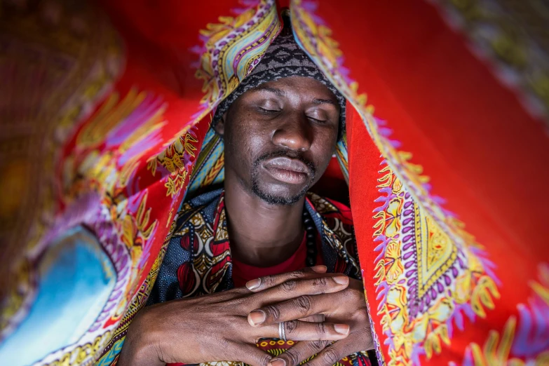 a man with hands in a cloth covering him