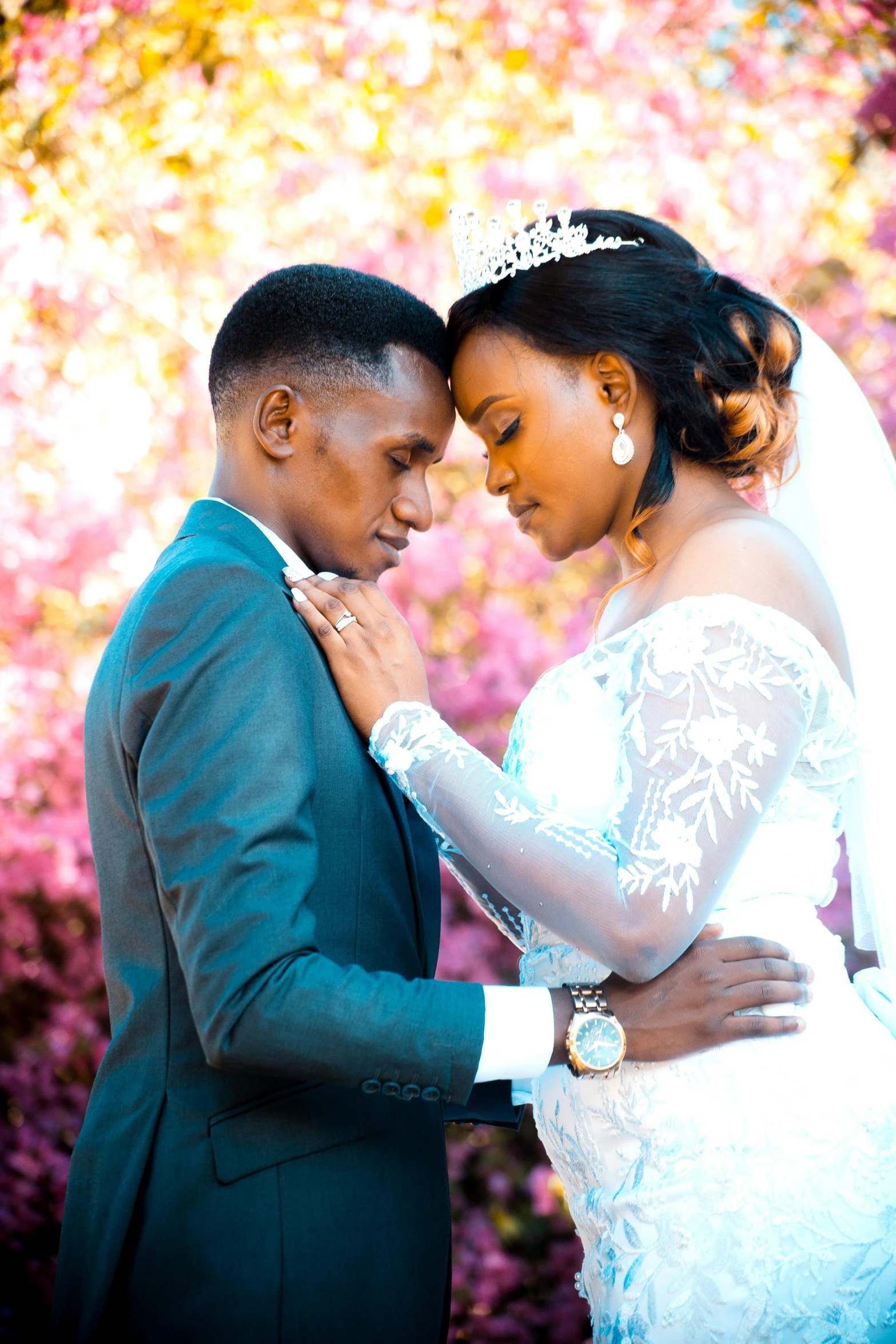 the bride and groom are in front of pink trees