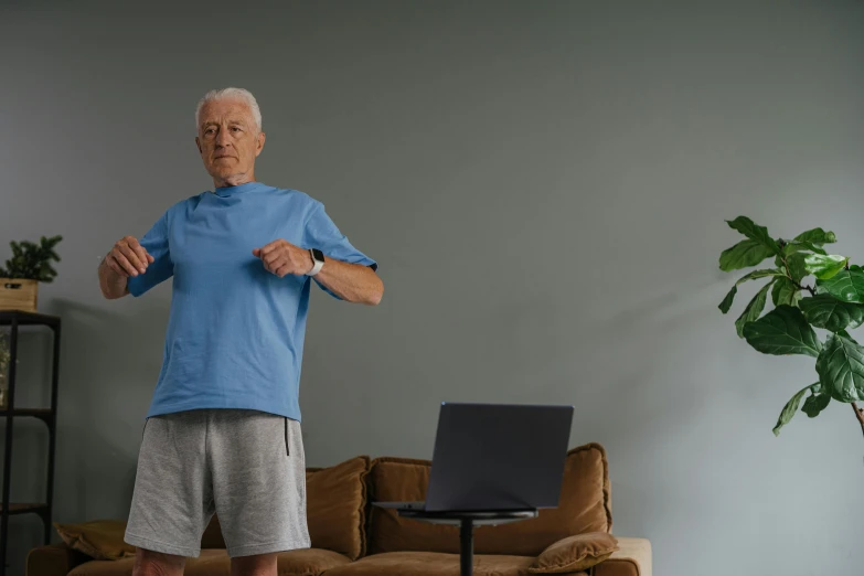 an elderly man stands on a scale in front of his couch