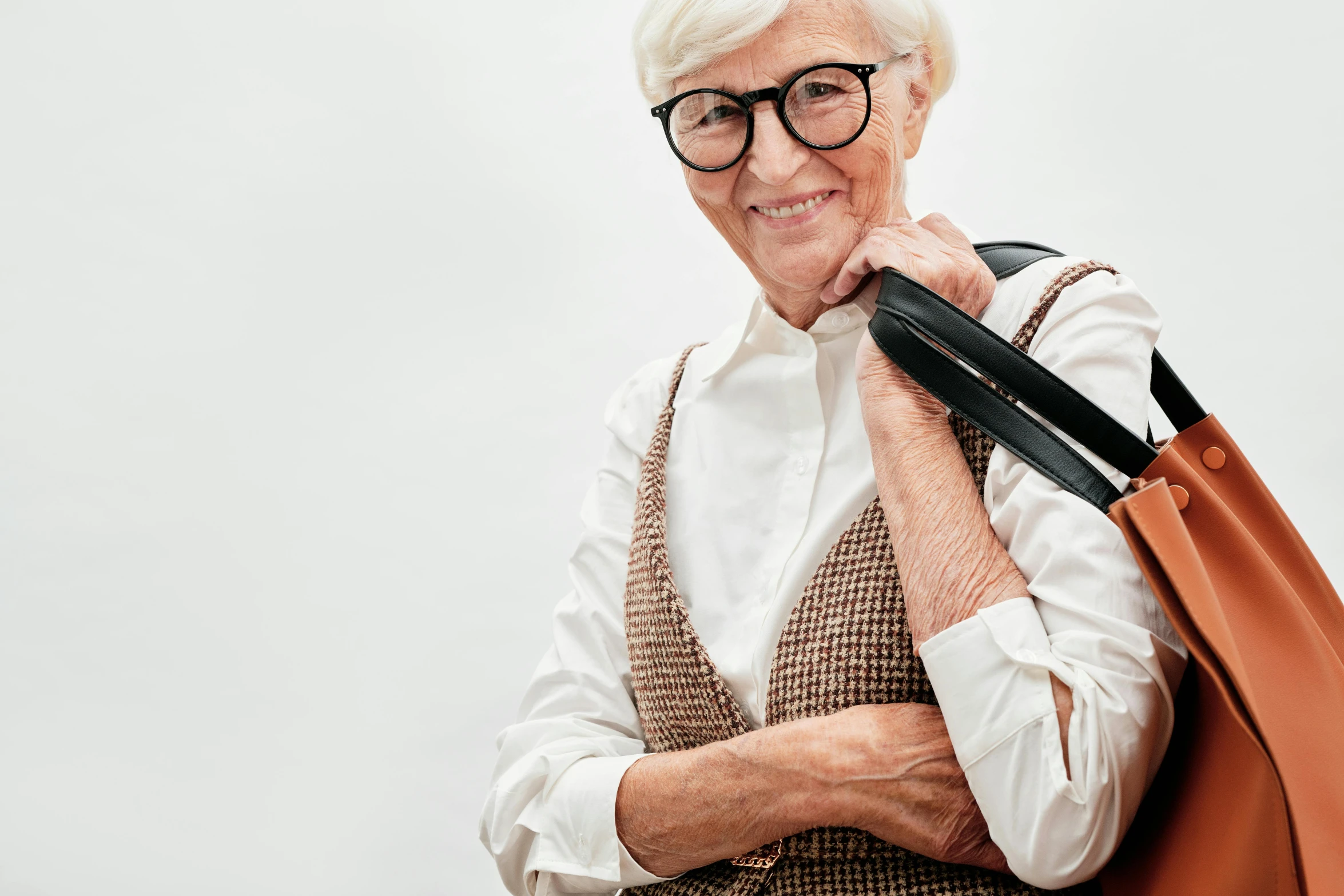 an old lady with glasses holding a brown handbag