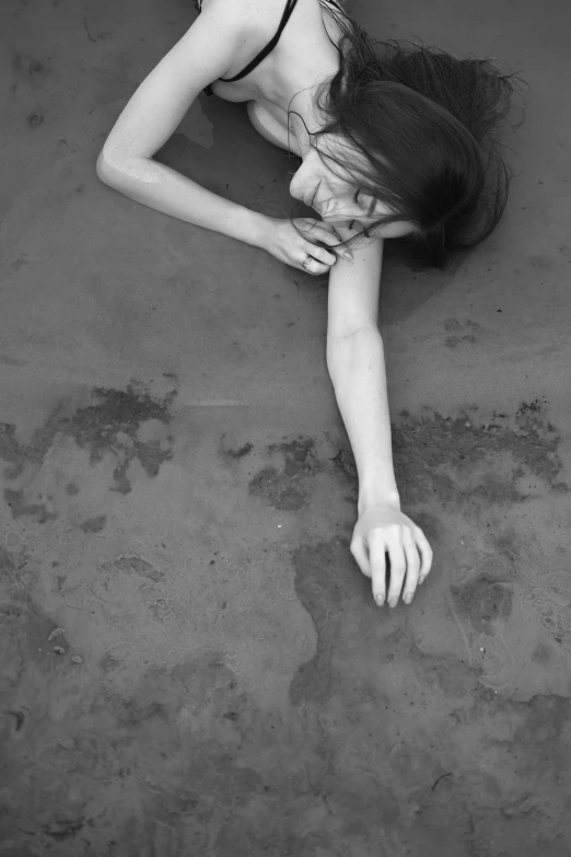 black and white pograph of a woman with her head on her stomach