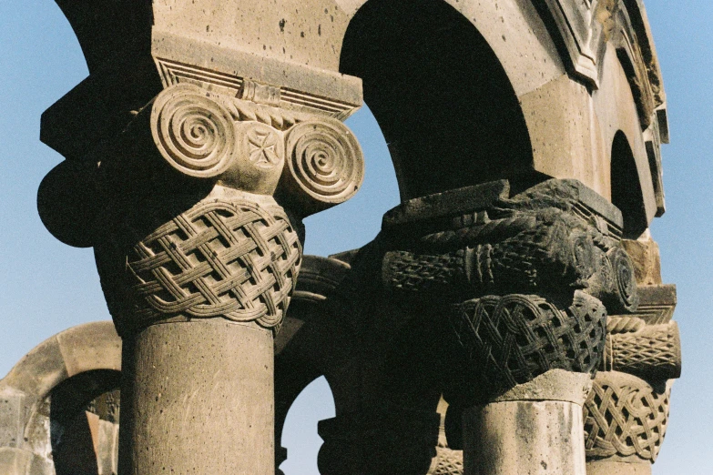 the base of an arch with a couring of three faces on it