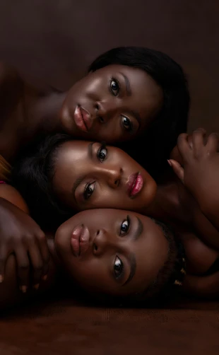 three women laying down and posing for the camera