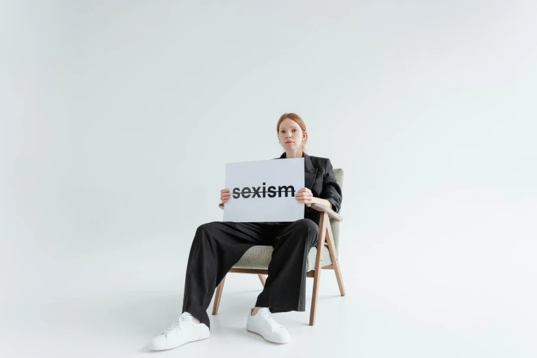 a woman in black shirt and black pants holding a sign