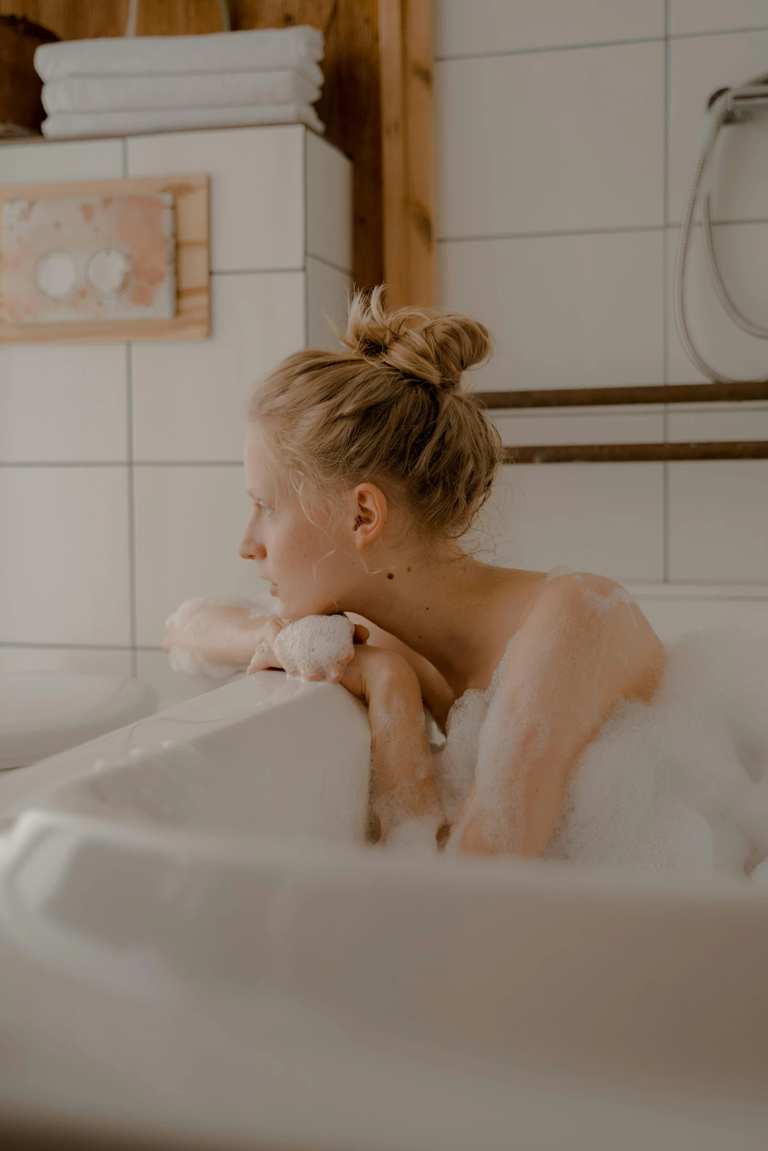 a woman is having a bath with her hair pulled in pigtails