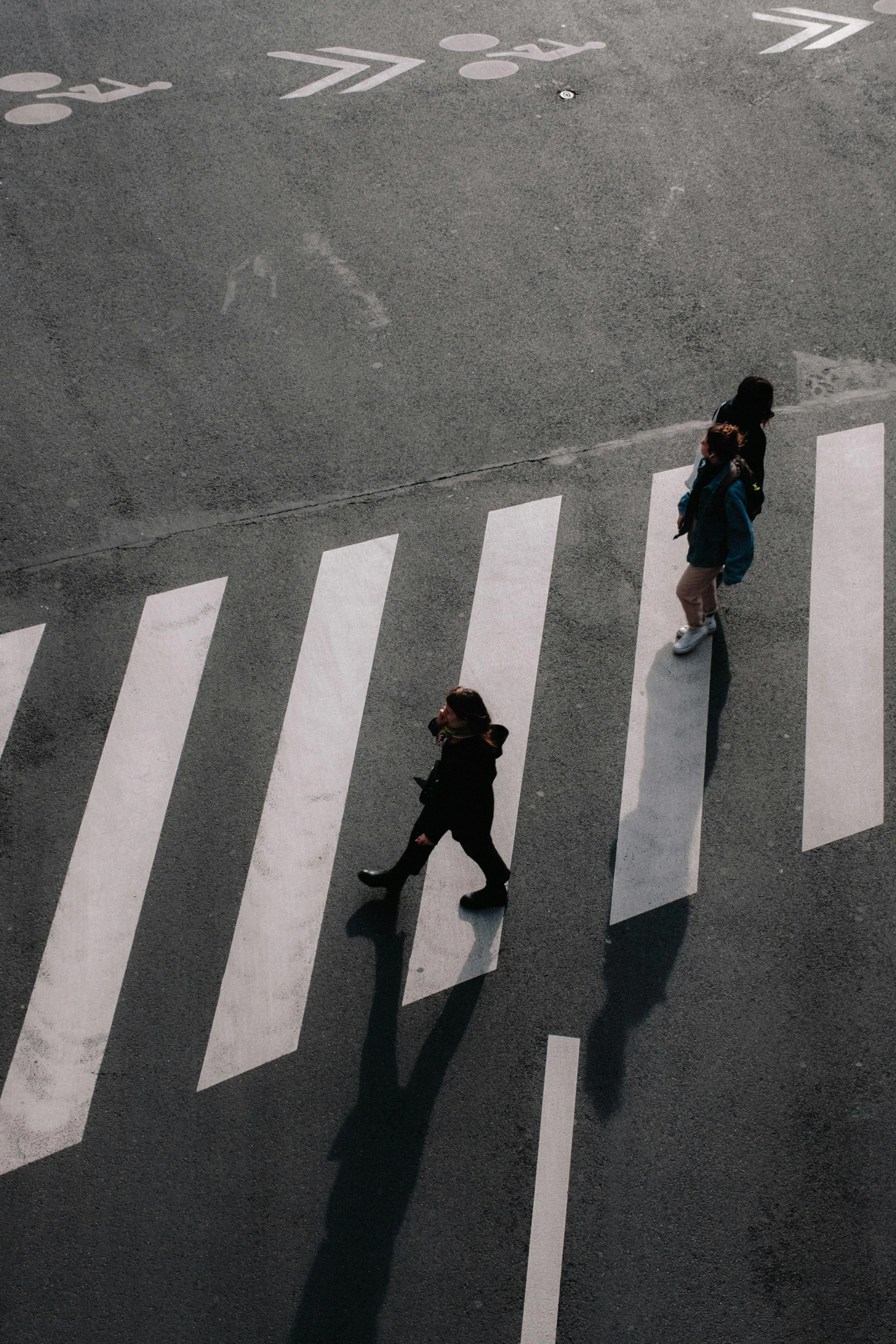 three people walking down a street carrying umbrellas