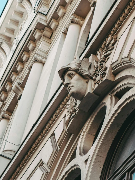 the statue of a lady in a hat hangs out front of the building