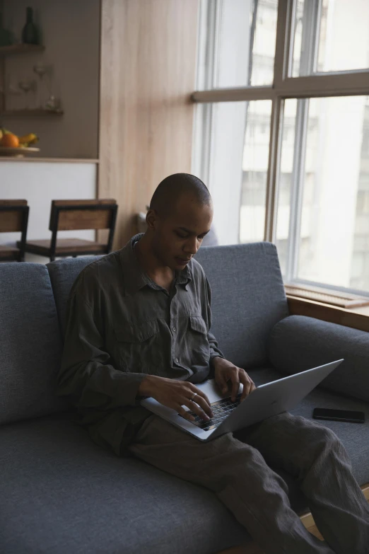 man sitting on the couch using his laptop