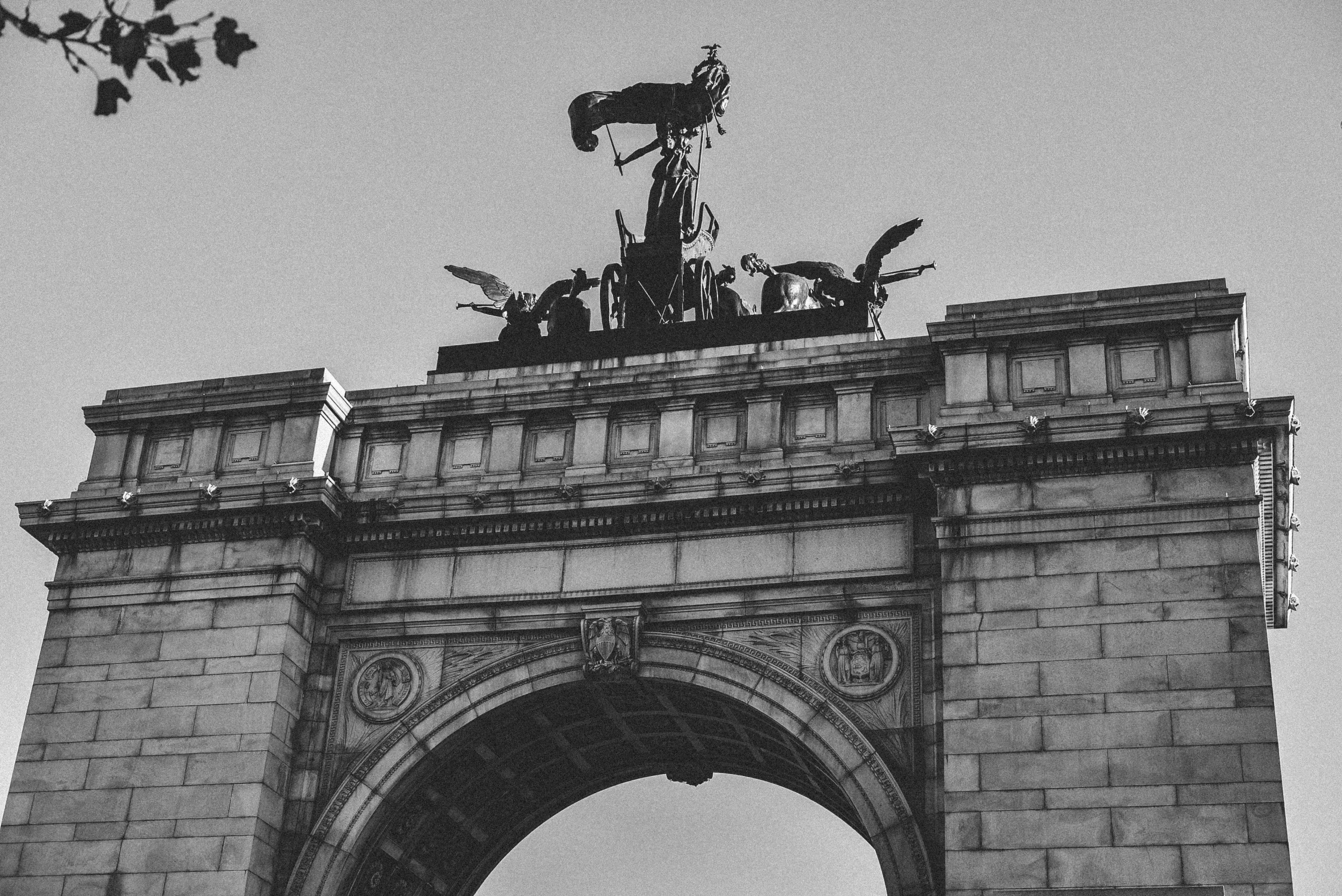 a black and white pograph of the arc of triumph with statues above it