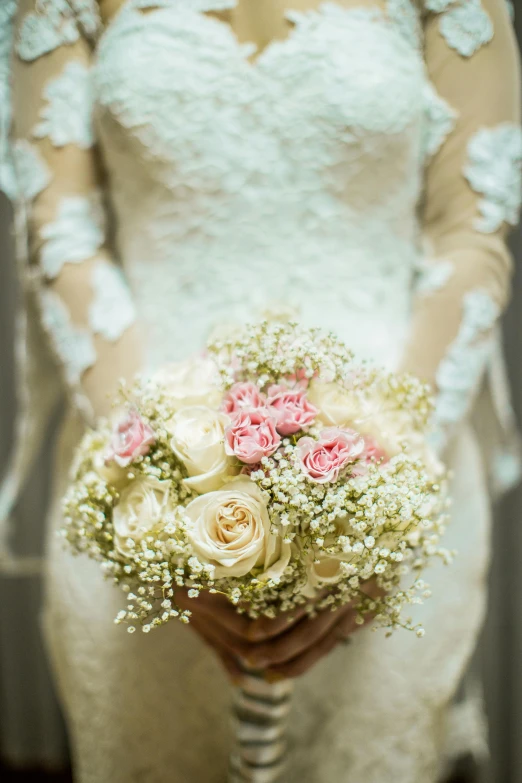 a bride holding her bouquet with pink and white flowers