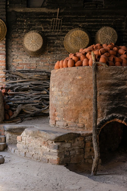 a pile of oranges in a clay oven area