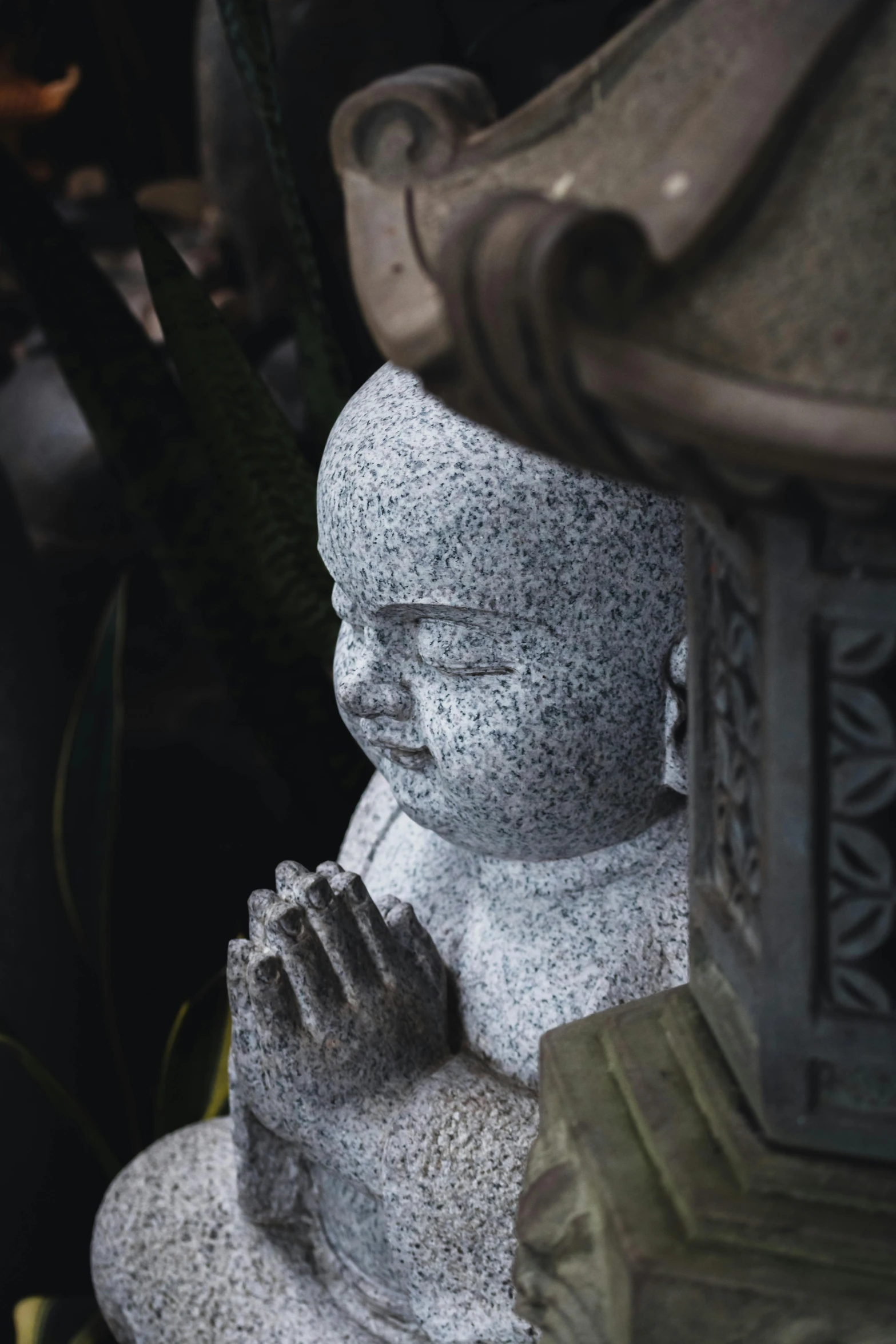 a small statue of a buddha praying with its hands clasped