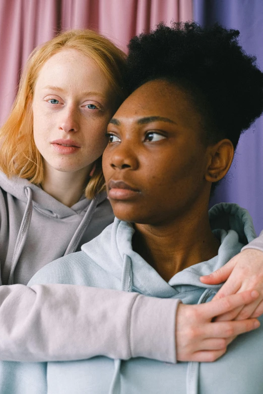 two young women hugging each other and posing for the camera