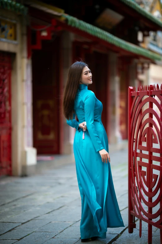 a woman is standing next to a red sculpture