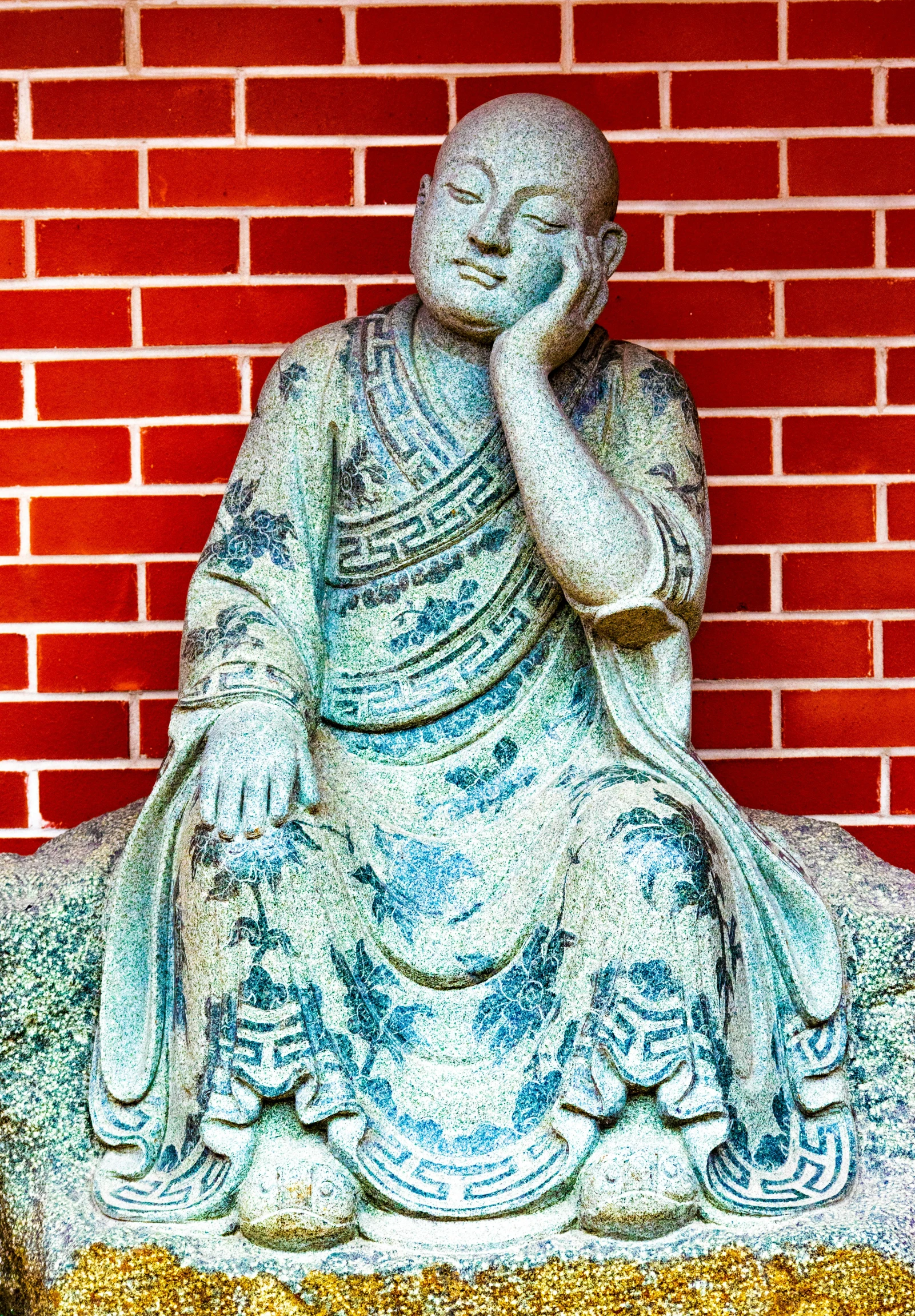 buddha statue sitting on top of a cement block