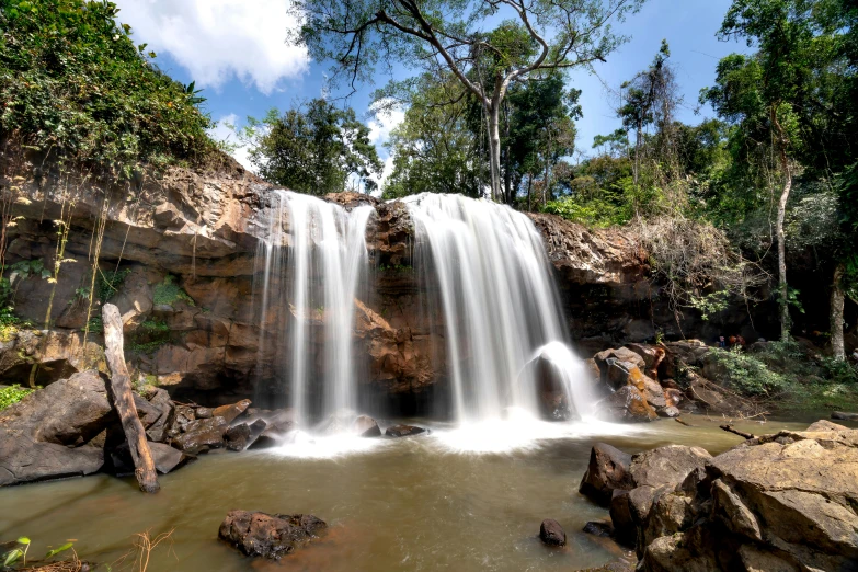 a small waterfall with rocks in the background