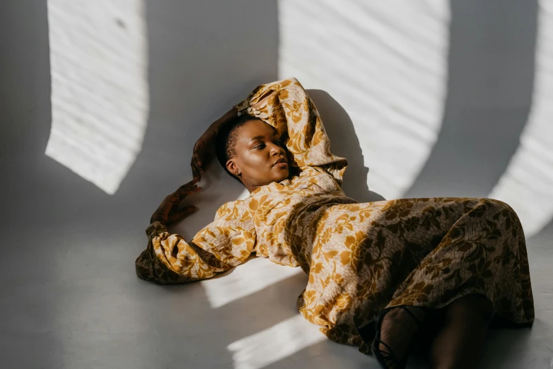 a woman lying down in a dress on the floor