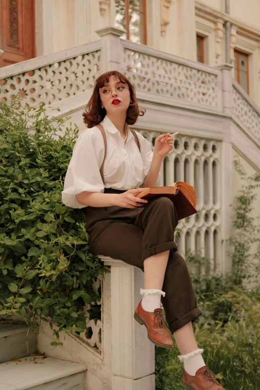 a woman sits outside in a dress with white shirt