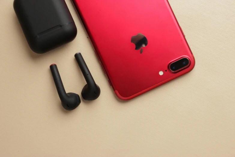 an electronic device on a table with ear buds and headphones