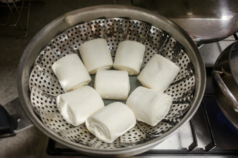 small cubes of food sit in a strainer on a stove