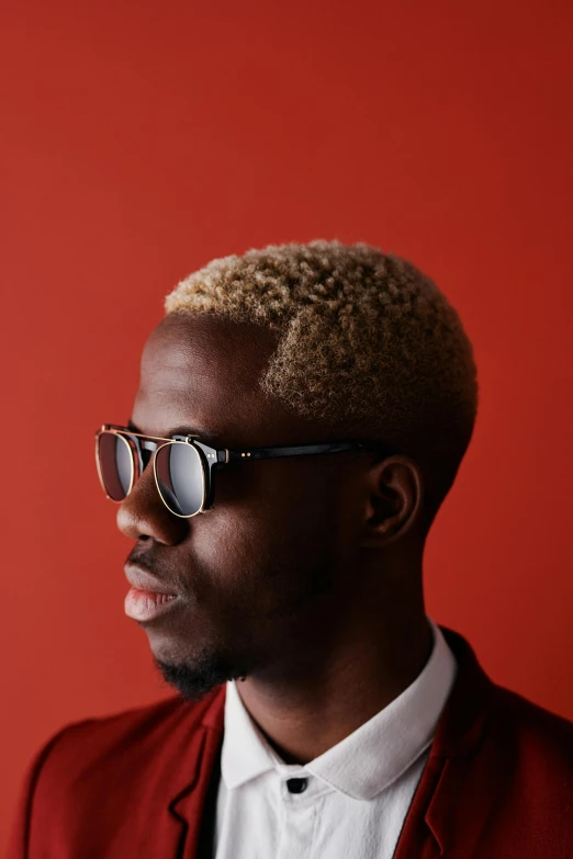 a man with red sunglasses wearing a maroon suit and white shirt