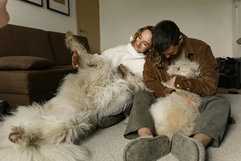 a woman holding two stuffed animals sitting next to two dogs