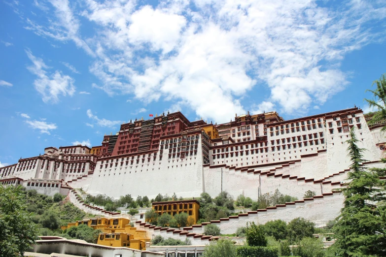 a white and brown castle that is on top of a hill